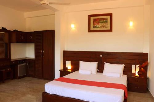a bedroom with a large bed with white sheets at Villa Royce in Kandy
