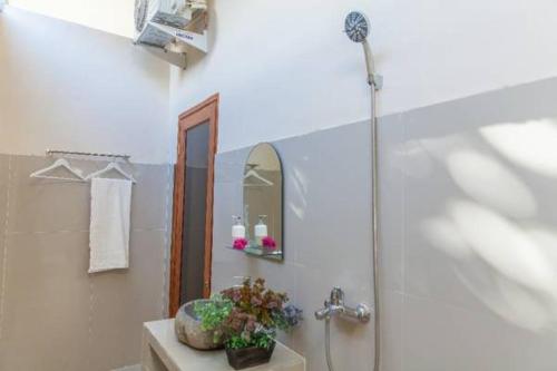 a bathroom with a shower and a sink with a mirror at Gili Desa in Gili Trawangan
