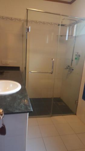 W łazience znajduje się szklana kabina prysznicowa i umywalka. w obiekcie Bougain Villa w mieście Bentota
