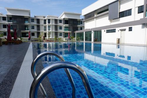 a swimming pool in front of a building at The Meadow Park in Kampar