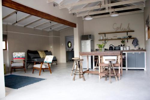 a kitchen and living room with a table and chairs at Avo&Oak Guesthouse in George
