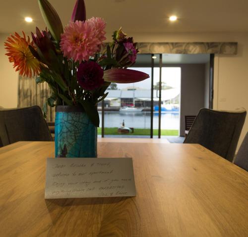 a vase filled with flowers sitting on top of a table at Ulverstone Waterfront Apartments in Ulverstone