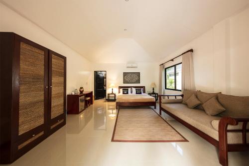 a living room with a couch and a bed at Cabilao Sanctuary Beach & Dive Resort in Loon