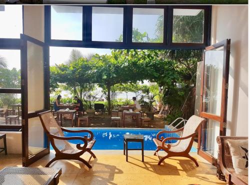 a room with chairs and a pool with a view at Talalla Bay Beach in Talalla