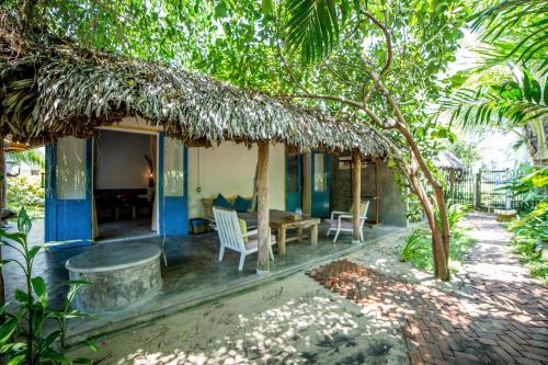 a house with a porch with a table and chairs at An Bang Hideaway in Hoi An