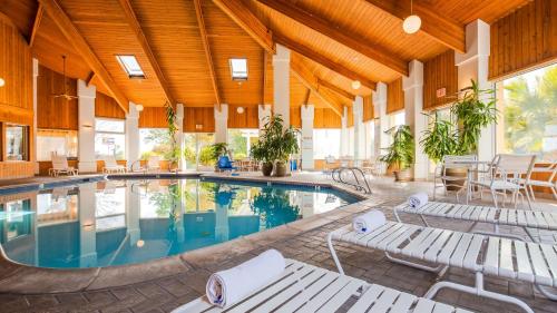 una gran piscina cubierta con sillas y mesa en Best Western Plus Corning Inn, en Corning