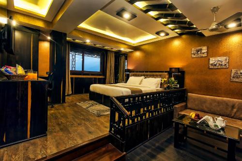 1 dormitorio con 1 cama y 1 sofá en una habitación en Amba Regency en Gangtok