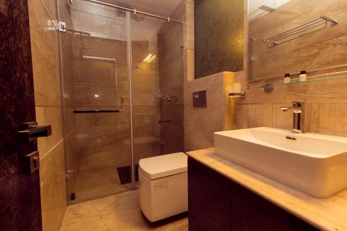 a bathroom with a sink and a shower and a toilet at Amba Regency in Gangtok