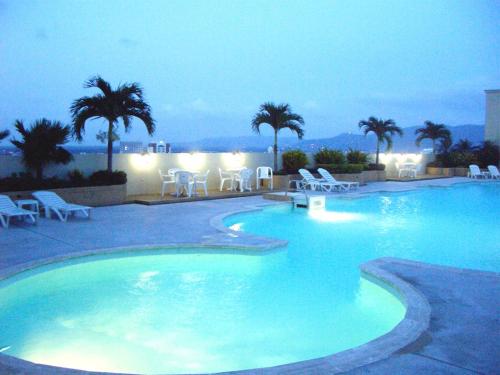 una gran piscina de agua azul por la noche en Lee Gardens Plaza Hotel - SHA Plus, en Hat Yai