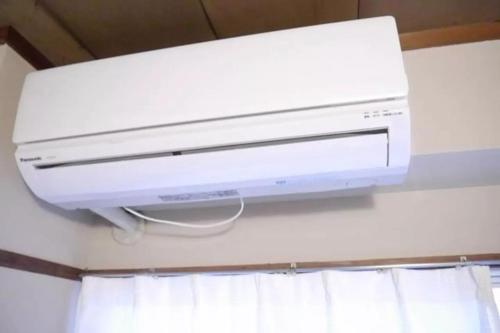 a white computer printer hanging from a ceiling at Fukuoka Condominium in Fukuoka