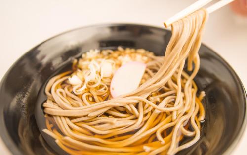 a bowl of noodles with a pair of chopsticks in it at Guest House COCO in Lake Toya