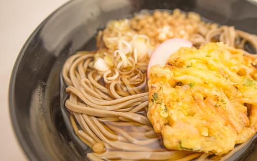 a bowl of food with noodles and other foods at Guest House COCO in Lake Toya