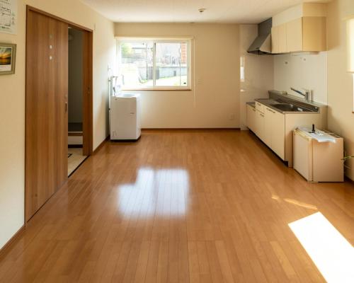 an empty kitchen with a hard wood floor at Guest House COCO in Lake Toya