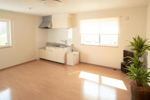 an empty living room with a kitchen and a table at Guest House COCO in Lake Toya