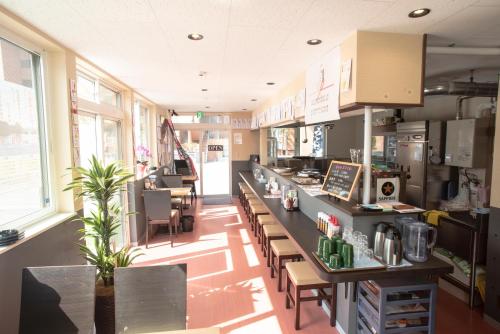 a restaurant with a counter and tables and chairs at Guest House COCO in Lake Toya