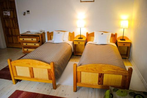 ミシレニツェにあるHotel Krakのベッド2台、ランプ2つ、テーブル2台が備わる客室です。