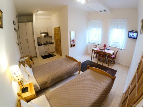 a living room with two beds and a dining room at Hotel Krak in Myślenice