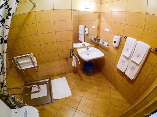 a bathroom with a sink and a toilet and towels at Hotel Krak in Myślenice