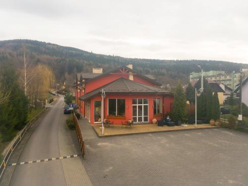 a red building on the side of a street at Hotel Krak in Myślenice