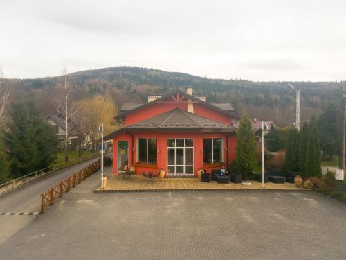 a red house in the middle of a road at Hotel Krak in Myślenice