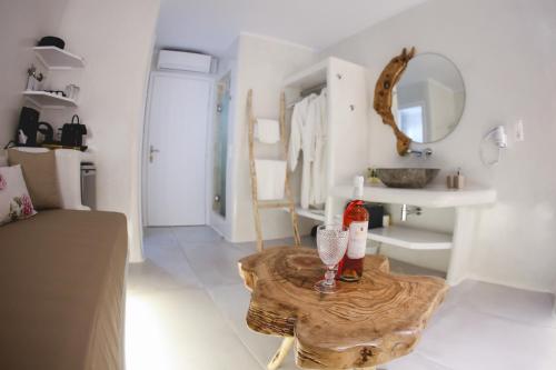 una sala de estar con una mesa en el centro de una habitación en Villa Elina suites and more en Agios Stefanos