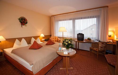 a hotel room with a large bed and a desk at May-Hof in Leverkusen