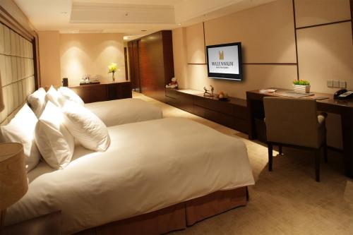 a hotel room with a bed and a desk at Millennium Hotel Wuxi in Wuxi