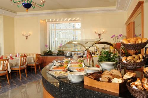 um buffet com pão e outros alimentos sobre uma mesa em Hotel Torbräu em Munique
