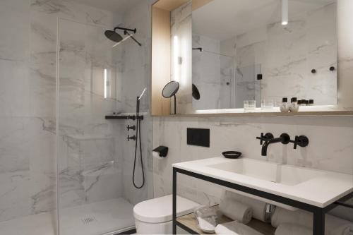 a bathroom with a toilet, sink, and shower at ICON Wipton in Madrid