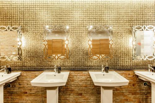 uma casa de banho pública com três lavatórios e espelhos em Gallery Lake View Hotel em Khon Kaen