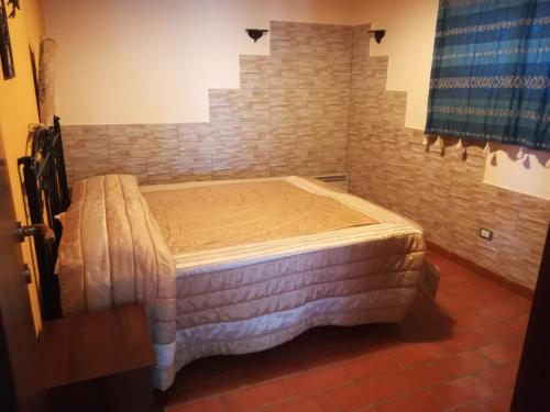 メンフィにあるCase di Campagna Lombardoのレンガの壁の客室の小さなベッド1台分です。