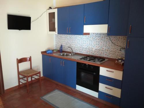 メンフィにあるCase di Campagna Lombardoのキッチン(青いキャビネット、シンク、椅子付)