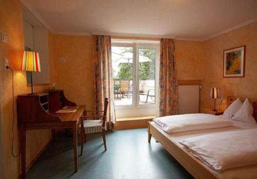 ザルツブルクにあるItzlingerhof Roomsのベッドルーム1室(ベッド1台、デスク、窓付)