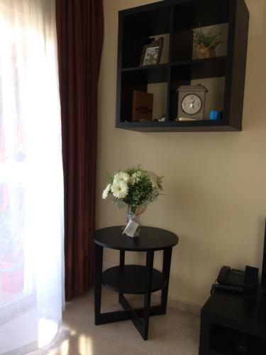 a table with a vase of flowers on it at Anastasia Apartments in Kargicak