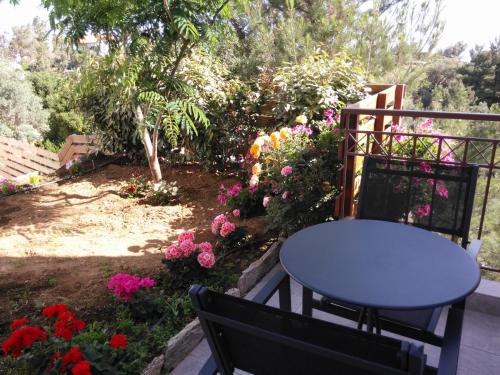 a table and chairs in a garden with flowers at Olivia Villas in Raches