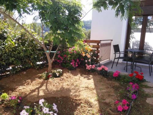 a garden with flowers and a tree on a porch at Olivia Villas in Raches