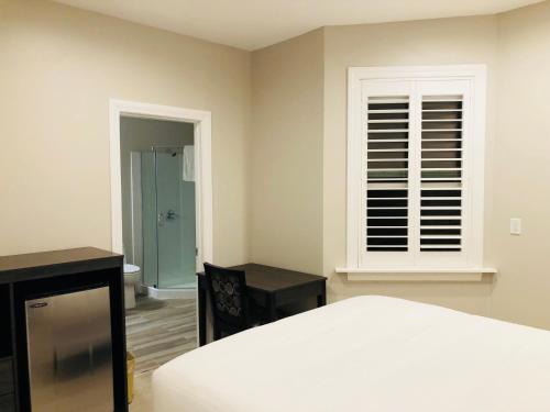 a bedroom with a bed and a window and a desk at Bay Hotel in San Francisco