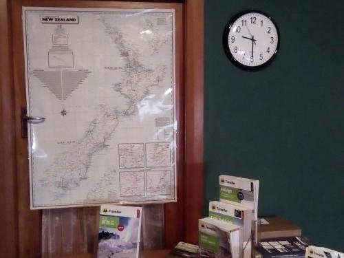 a clock on a wall next to a map at Redwood Lodge Motel in Levin
