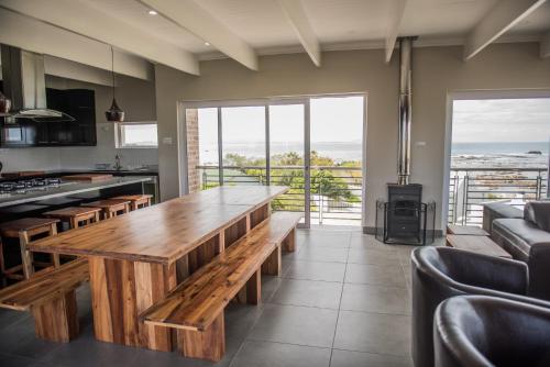 a kitchen with a wooden table in a room at Villa Vue in Kleinbaai