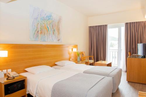 a hotel room with two beds and a television at Athinais Hotel in Athens