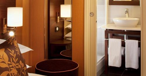 une salle de bain avec un lavabo, des toilettes et un miroir dans l'établissement Hôtel 85 Saint Honore, à Paris