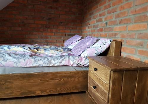 a bedroom with a bed and a brick wall at Baba Jagna in Chocimów
