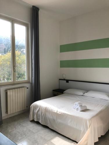 a bedroom with a white bed and a window at Hotel Garden Bocca di Magra in Bocca di Magra