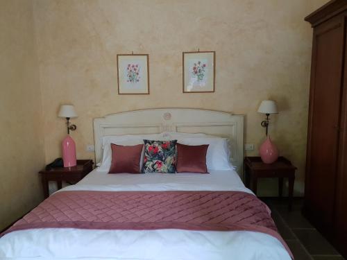 a bedroom with a large white bed with two lamps at I giardini segreti di Villa Marcello Marinelli in Cison di Valmarino