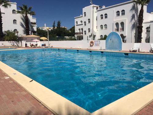 a large swimming pool in front of a building at Tavira Garden- One Bedroom with Terrace in Tavira