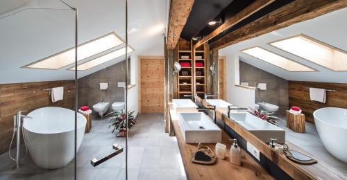 een badkamer met 2 wastafels en een groot bad bij Zum Alten Moar in Bressanone