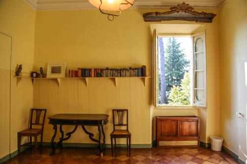 ein Tisch und zwei Stühle in einem Zimmer mit Fenster in der Unterkunft Villa Malacari in Offagna