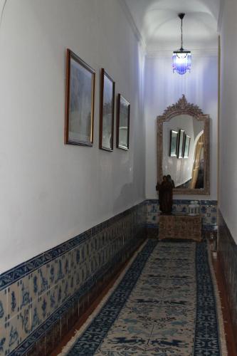 a hallway with a mirror and a rug at Casa D. Diogo in Arraiolos