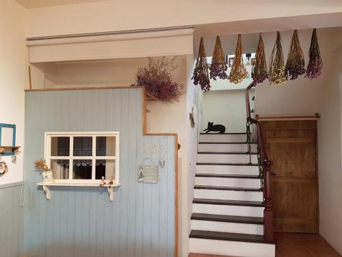 a hallway with a staircase leading to a room with a door at Village Villa B&B in Zhuqi