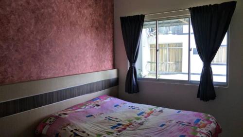 um quarto com uma cama e uma janela em Rose Apartment Kea Farm em Cameron Highlands